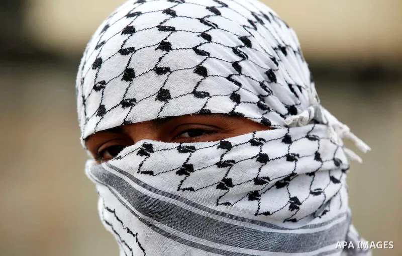A Palestinian protester looks out during clashes with Israeli security forces following a demonstration against the expropriation of Palestinian land by Israel in the village of Kfar Qaddum, near Nablus in the occupied W...