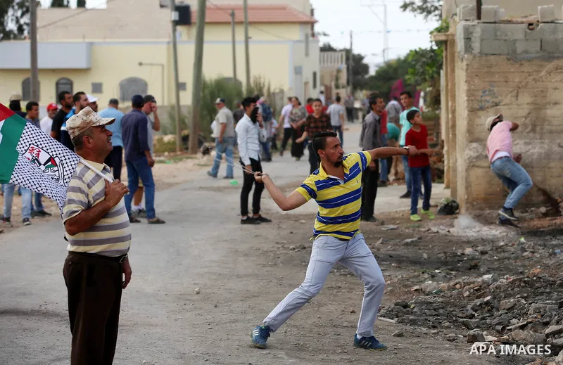 Palestinian protesters throw stones towards Israeli security forces during clashes following a demonstration against the expropriation of Palestinian land by Israel in the village of Kfar Qaddum, near Nablus in the occup...