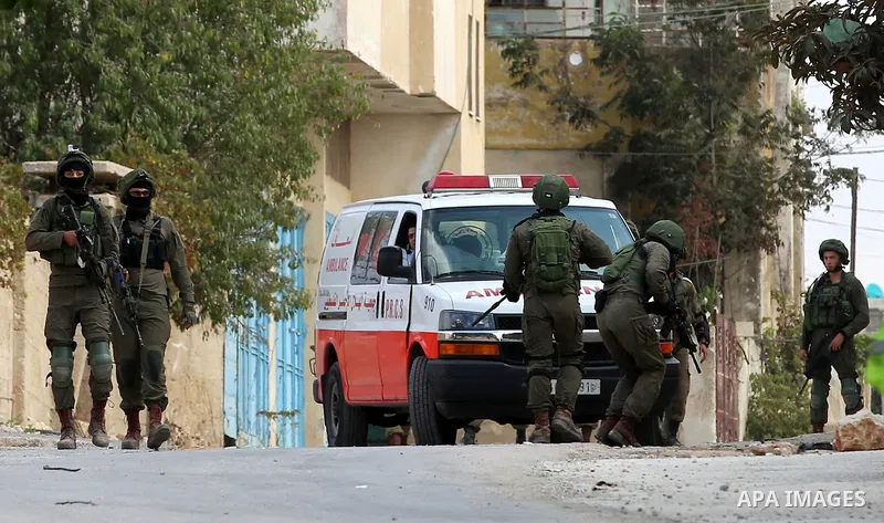 Israeli security forces hinder the movement of a Palestinian ambulance during clashes with Palestinian protesters following a demonstration against the expropriation of Palestinian land by Israel in the village of Kfar Q...