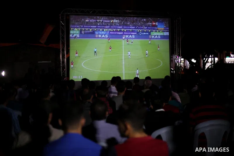 Palestinian fans watch the World Cup 2018 Africa qualifying football match between Egypt and Congo via large screens in Gaza City on October 8, 2017. Photo by Mohammed Asad