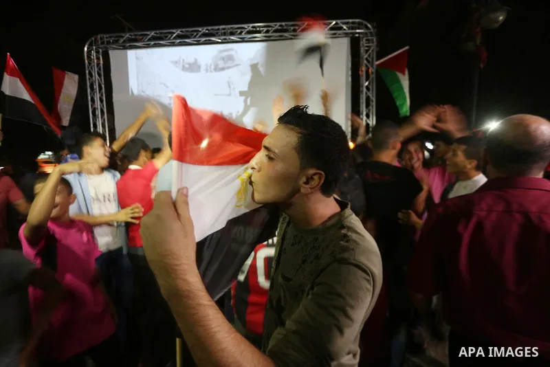 Palestinian fans watch the World Cup 2018 Africa qualifying football match between Egypt and Congo via large screens in Gaza City on October 8, 2017. Photo by Mohammed Asad