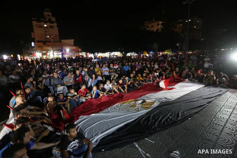 Palestinian fans watch the World Cup 2018 Africa qualifying football match between Egypt and Congo via large screens in Gaza City on October 8, 2017. Photo by Mohammed Asad