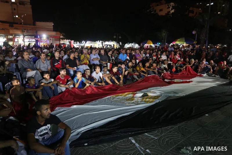 Palestinian fans watch the World Cup 2018 Africa qualifying football match between Egypt and Congo via large screens in Gaza City on October 8, 2017. Photo by Mohammed Asad