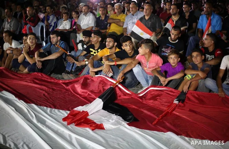 Palestinian fans watch the World Cup 2018 Africa qualifying football match between Egypt and Congo via large screens in Gaza City on October 8, 2017. Photo by Mohammed Asad
