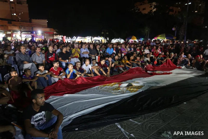 Palestinian fans watch the World Cup 2018 Africa qualifying football match between Egypt and Congo via large screens in Gaza City on October 8, 2017. Photo by Mohammed Asad