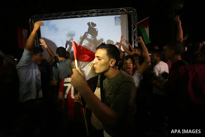 Palestinian fans watch the World Cup 2018 Africa qualifying football match between Egypt and Congo via large screens in Gaza City on October 8, 2017. Photo by Mohammed Asad