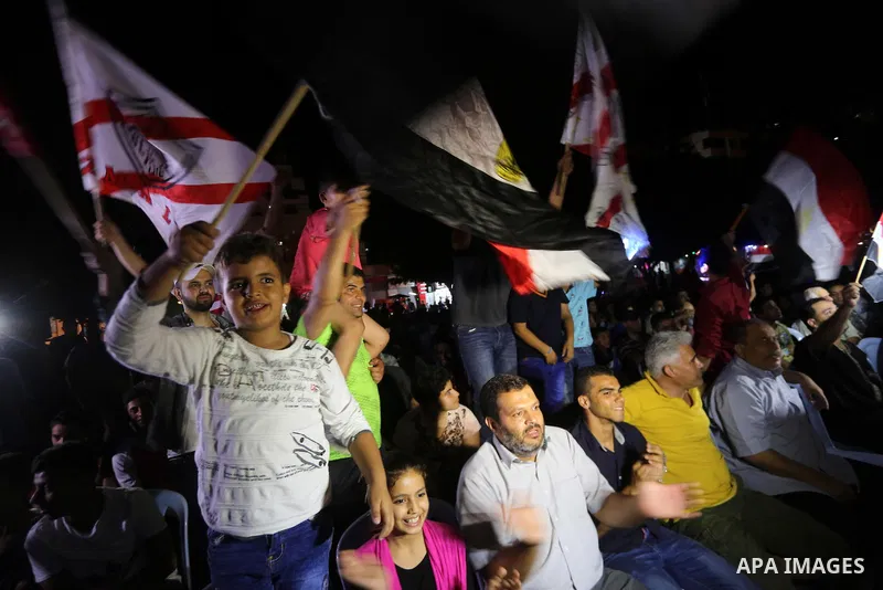 Palestinian fans watch the World Cup 2018 Africa qualifying football match between Egypt and Congo via large screens in Gaza City on October 8, 2017. Photo by Mohammed Asad