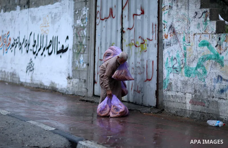 A Palestinian man walks in a street flooded by rain water, in Gaza city on October 9, 2017. Photo by Atia Darwish