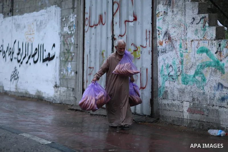 A Palestinian man walks in a street flooded by rain water, in Gaza city on October 9, 2017. Photo by Atia Darwish