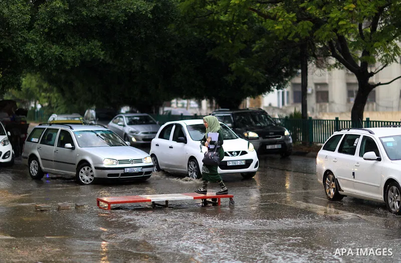 Palestinian students walk in a street flooded by rain water, in Gaza city on October 9, 2017. Photo by Atia Darwish