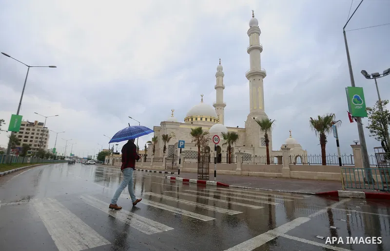 A Palestinian man walks in a street flooded by rain water, in Gaza city on October 9, 2017. Photo by Atia Darwish