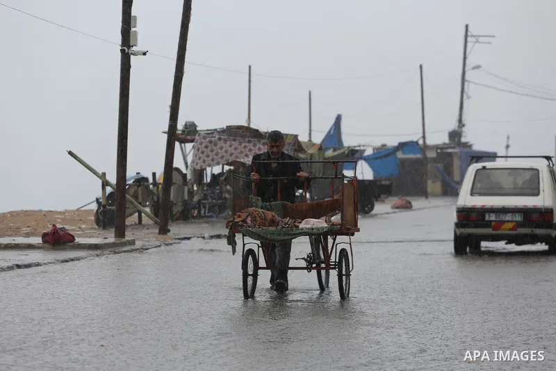 A Palestinian man rides a cart in a street flooded by rain water, in Gaza city on October 9, 2017. Photo by Mohammed Asad