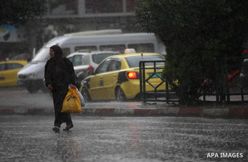 Palestinians walk in a street flooded by rain water, in the West Bank city of Nablus, on October 9, 2017. Photo by Ayman Ameen