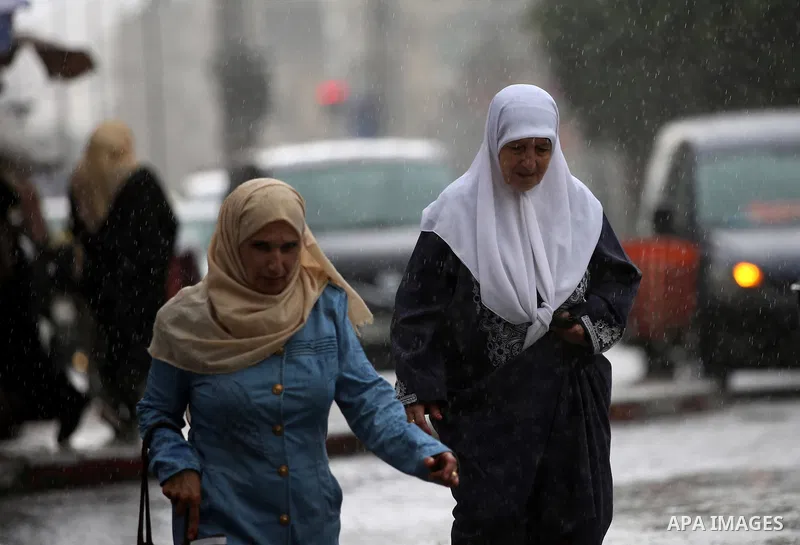 Palestinians walk in a street flooded by rain water, in the West Bank city of Nablus, on October 9, 2017. Photo by Ayman Ameen