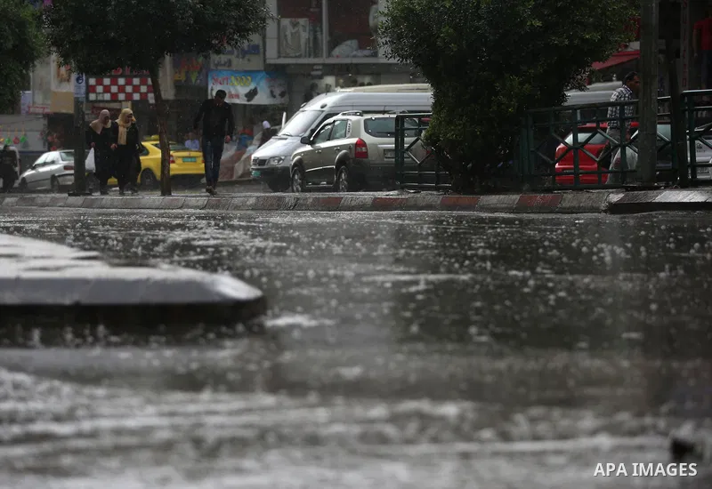 Palestinians walk in a street flooded by rain water, in the West Bank city of Nablus, on October 9, 2017. Photo by Ayman Ameen
