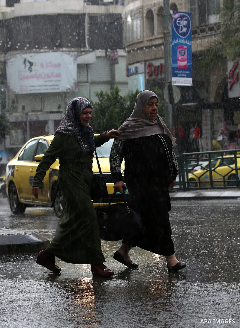 Palestinians walk in a street flooded by rain water, in the West Bank city of Nablus, on October 9, 2017. Photo by Ayman Ameen