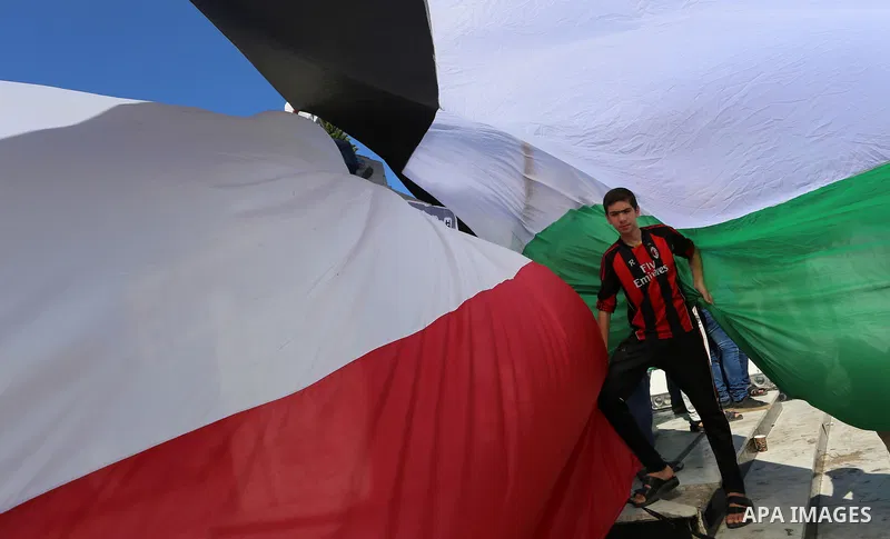 Palestinians wave the flags of Egypt, Palestine, Fatah and Hamas as they gather in Gaza City to celebrate after rival Palestinian factions Hamas and Fatah reached an agreement on ending a decade-long split following talk...
