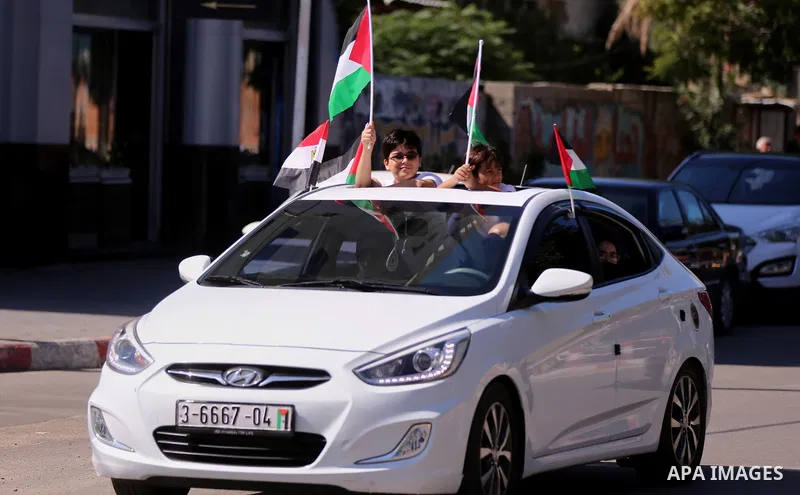 Palestinians wave the flags of Egypt, Palestine, Fatah and Hamas as they gather in Gaza City to celebrate after rival Palestinian factions Hamas and Fatah reached an agreement on ending a decade-long split following talk...