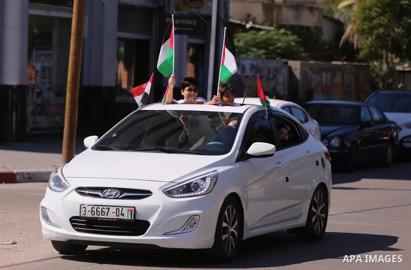 Palestinians wave the flags of Egypt, Palestine, Fatah and Hamas as they gather in Gaza City to celebrate after rival Palestinian factions Hamas and Fatah reached an agreement on ending a decade-long split following talk...