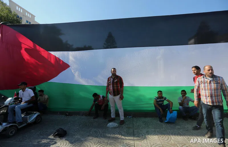 Palestinians wave the flags of Egypt, Palestine, Fatah and Hamas as they gather in Gaza City to celebrate after rival Palestinian factions Hamas and Fatah reached an agreement on ending a decade-long split following talk...