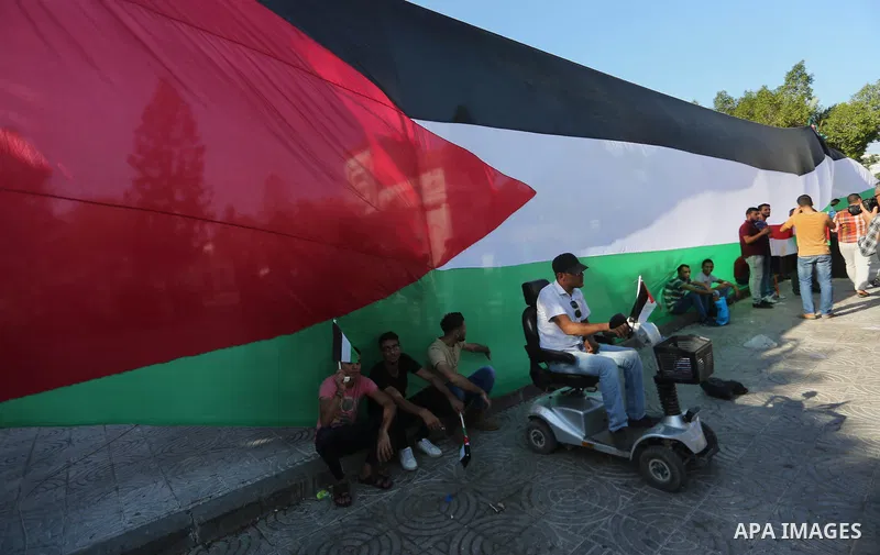 Palestinians wave the flags of Egypt, Palestine, Fatah and Hamas as they gather in Gaza City to celebrate after rival Palestinian factions Hamas and Fatah reached an agreement on ending a decade-long split following talk...