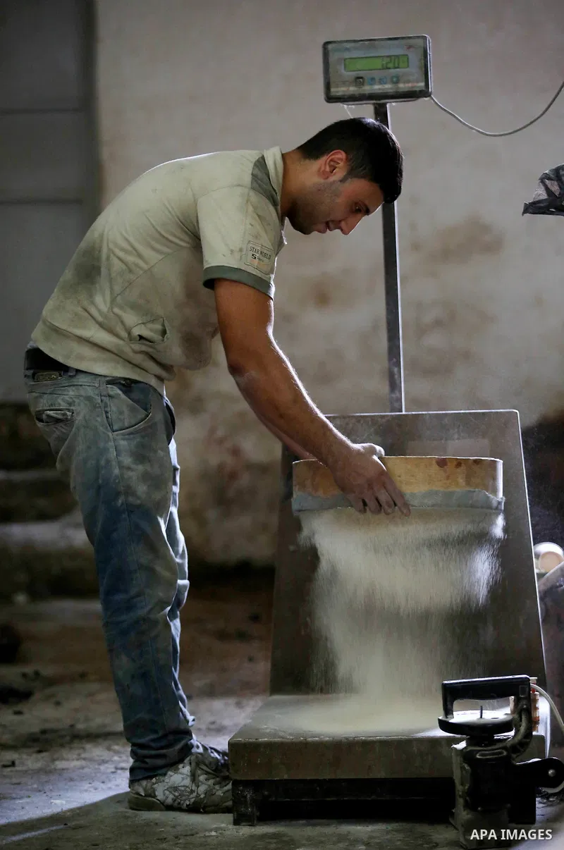 Palestinian laborers work at a Al-Adham old flour mill in the old town of West Bank city of Nablus October 10, 2017. Al-Adham mill Was founded in 1945 and grinds all kinds of grains, such as wheat, beans, chickpeas, on m...
