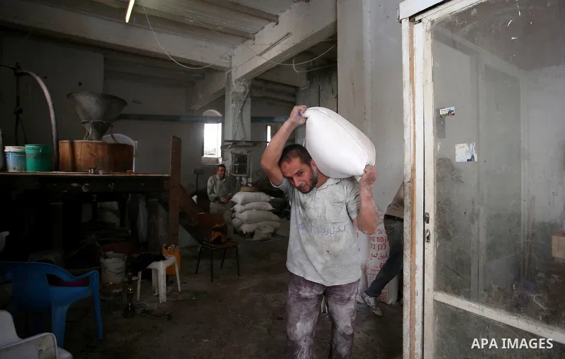 Palestinian laborers work at a Al-Adham old flour mill in the old town of West Bank city of Nablus October 10, 2017. Al-Adham mill Was founded in 1945 and grinds all kinds of grains, such as wheat, beans, chickpeas, on m...