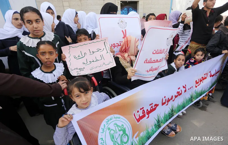 Palestinians hold placards during a protest against World Food Programme (WFP) decision to stop food aid in front of United Nations Development Programme office (UNDP), in Gaza City, on October 19, 2017. Thirty-five inst...