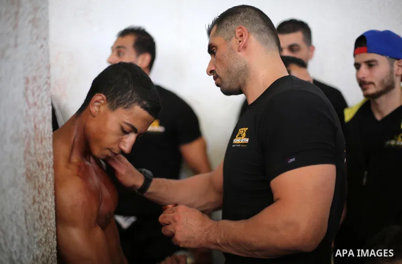 A Palestinian participant prepares himself before a bodybuilding competition, which organized by Palestinian Federation of Bodybuilding and Fitness (PFBB), in Gaza city on October 20, 2017. Photo by Mohammed Asad