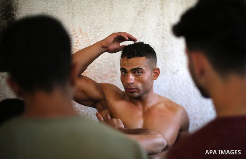 A Palestinian participant prepares himself before a bodybuilding competition, which organized by Palestinian Federation of Bodybuilding and Fitness (PFBB), in Gaza city on October 20, 2017. Photo by Mohammed Asad