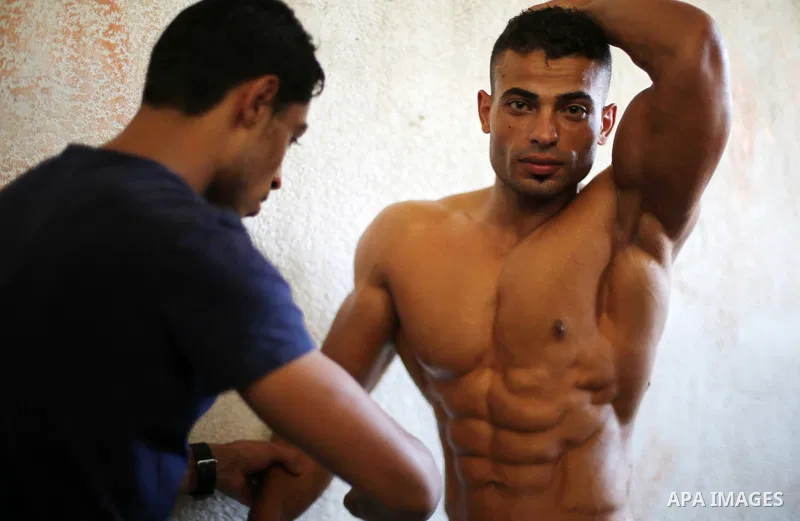 A Palestinian participant prepares himself before a bodybuilding competition, which organized by Palestinian Federation of Bodybuilding and Fitness (PFBB), in Gaza city on October 20, 2017. Photo by Mohammed Asad