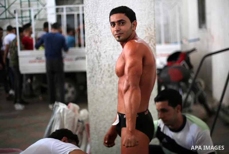 A Palestinian participant prepares himself before a bodybuilding competition, which organized by Palestinian Federation of Bodybuilding and Fitness (PFBB), in Gaza city on October 20, 2017. Photo by Mohammed Asad