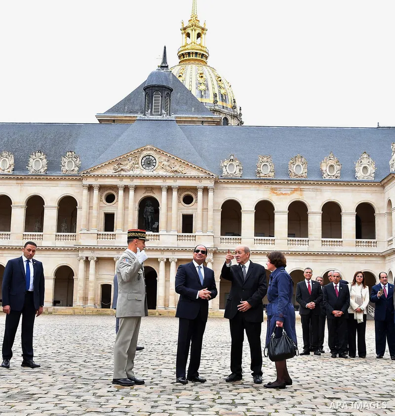 Egyptian President Abdel Fattah al-Sisi, French Foreign Affairs Minister Jean-Yves Le Drian and Paris military Governor Bruno Le Ray stand in front of the statue of Napoleon during a military ceremony at the Hotel des In...