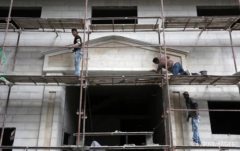 Palestinian laborers construction work at building still under construction, in Gaza city on October 28, 2017. Property owners in the Gaza Strip suffer from weak market and sales, and according to World Bank's report Gaz...