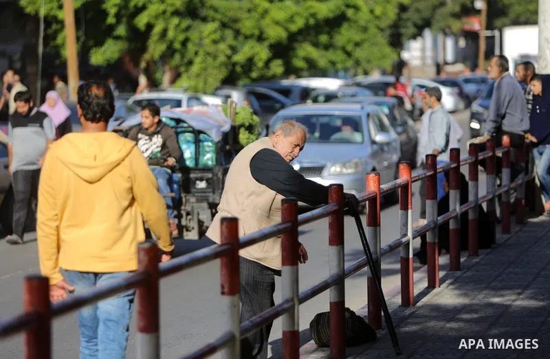 Palestinians of Social Affairs wait in front of Bank of Palestine to withdrew their financial aid in Gaza City on October 29, 2017. Photo by Atia Darwish