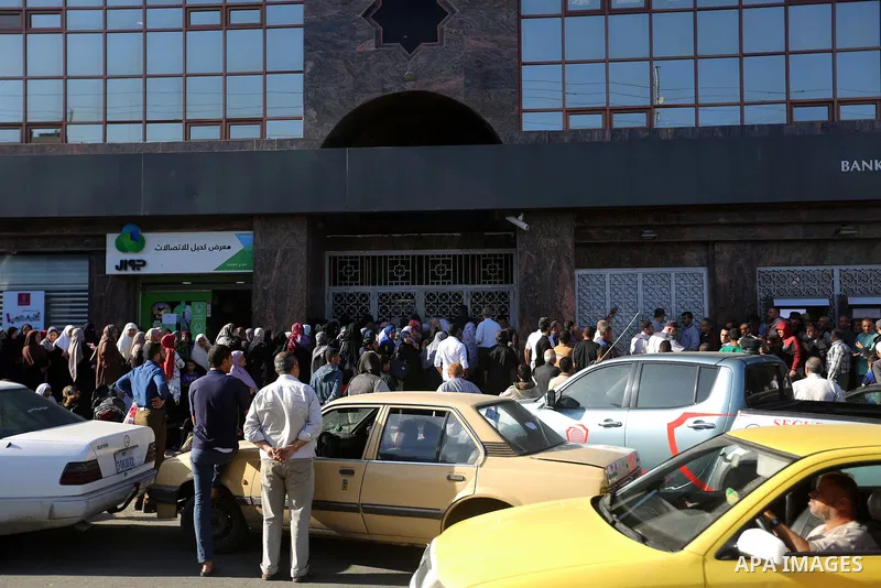 Palestinians of Social Affairs wait in front of Bank of Palestine to withdrew their financial aid in Gaza City on October 29, 2017. Photo by Atia Darwish