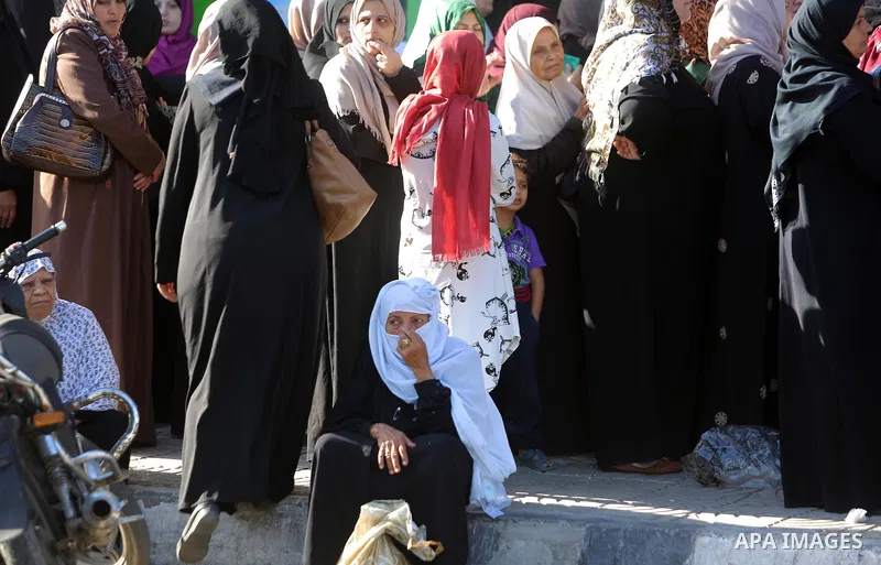 Palestinians of Social Affairs wait in front of Bank of Palestine to withdrew their financial aid in Gaza City on October 29, 2017. Photo by Atia Darwish
