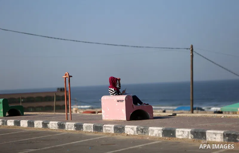 A Palestinian woman sits at the beach of Gaza sea on October 29, 2017. Photo by Atia Darwish