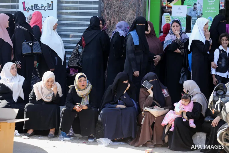 Palestinians of Social Affairs wait in front of Bank of Palestine to withdrew their financial aid in Gaza City on October 29, 2017. Photo by Mohammed Asad