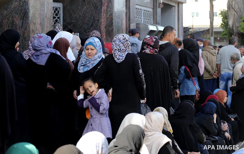 Palestinians of Social Affairs wait in front of Bank of Palestine to withdrew their financial aid in Gaza City on October 29, 2017. Photo by Mohammed Asad
