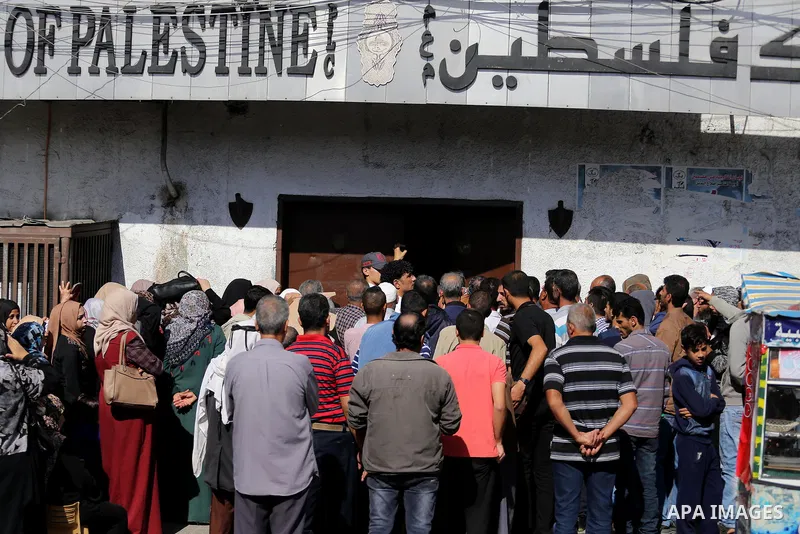 Palestinians of Social Affairs wait in front of Bank of Palestine to withdrew their financial aid in Gaza City on October 29, 2017. Photo by Mohammed Asad