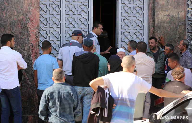 Palestinians of Social Affairs wait in front of Bank of Palestine to withdrew their financial aid in Gaza City on October 29, 2017. Photo by Yasser Qudih