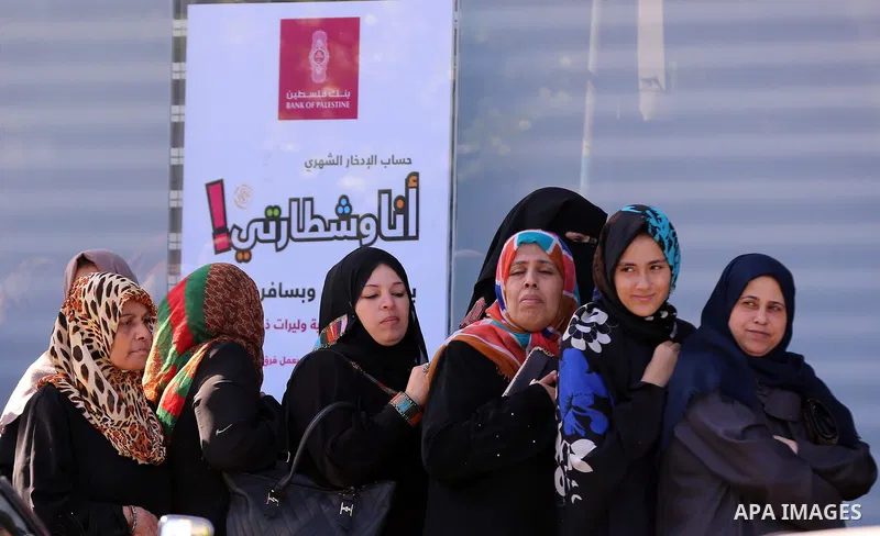 Palestinians of Social Affairs wait in front of Bank of Palestine to withdrew their financial aid in Gaza City on October 29, 2017. Photo by Yasser Qudih
