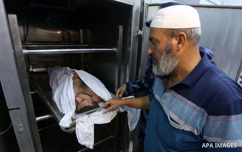 The body of Palestinian killed after Israel blew up what it said was a tunnel stretching from the Gaza Strip into its territory, lies at a morgue at al-Aqsa hospital in Deir el-Balah, in central Gaza, on October 30, 2017...