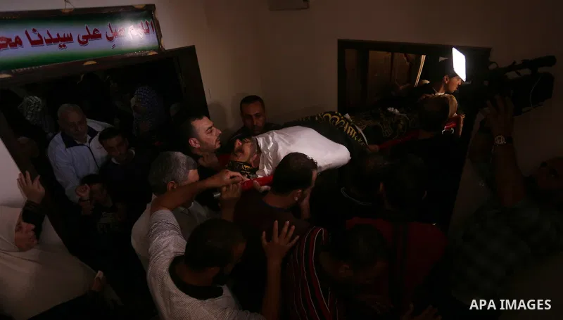 Palestinian relatives of Hassan Abu Hassanin who were killed the previous day in an Israeli operation to blow up a tunnel stretching from the Gaza Strip into Israel, mourn during his funeral in Bureij refugee camp in cen...