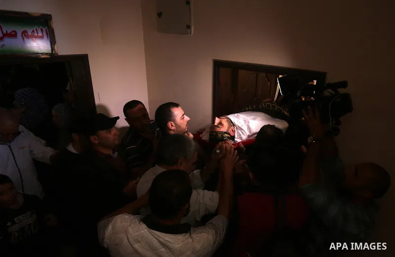 Palestinian relatives of Hassan Abu Hassanin who were killed the previous day in an Israeli operation to blow up a tunnel stretching from the Gaza Strip into Israel, mourn during his funeral in Bureij refugee camp in cen...