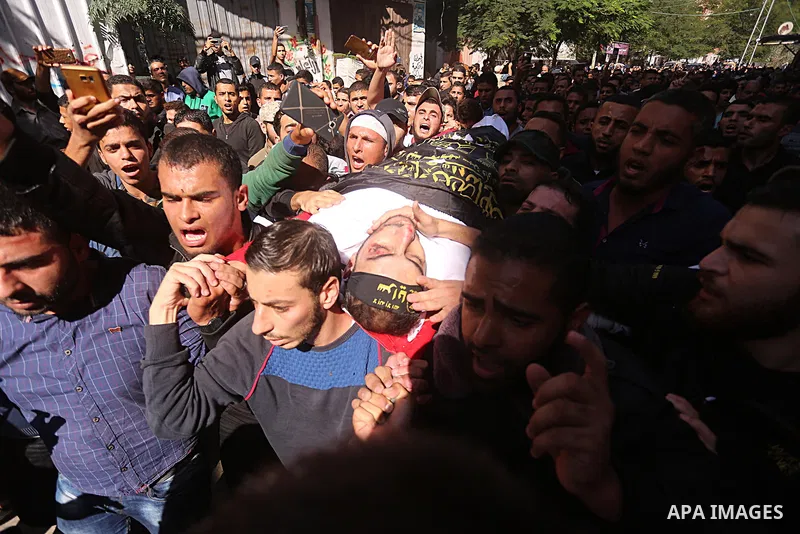 Palestinian mourners carry the body of Hassan Abu Hassanin in Bureij refugee camp in central Gaza Strip on October 31, 2017, during the funeral of Palestinians who were killed the previous day in an Israeli operation to...