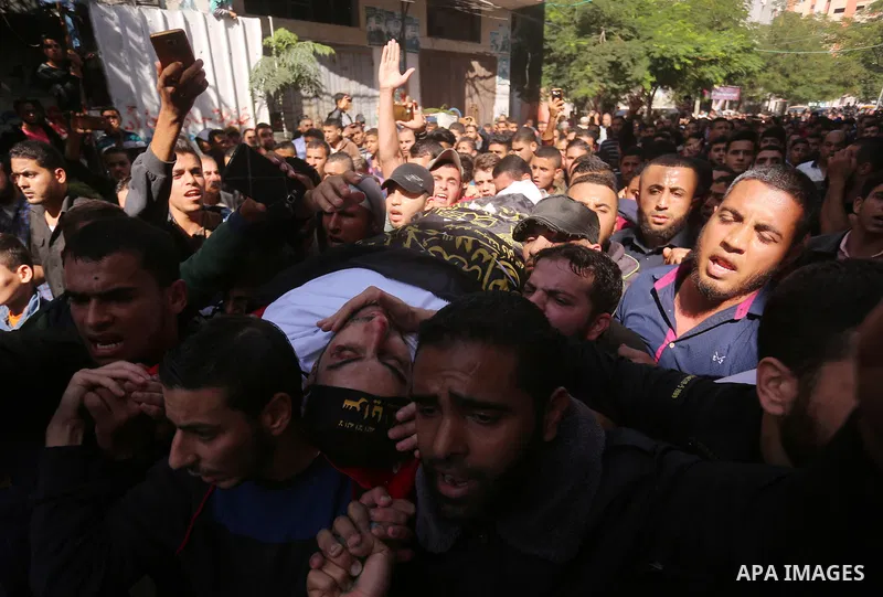 Palestinian mourners carry the body of Hassan Abu Hassanin in Bureij refugee camp in central Gaza Strip on October 31, 2017, during the funeral of Palestinians who were killed the previous day in an Israeli operation to...