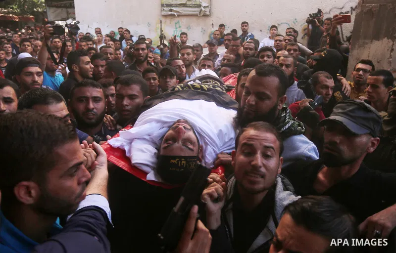 Palestinian mourners carry the body of Hassan Abu Hassanin in Bureij refugee camp in central Gaza Strip on October 31, 2017, during the funeral of Palestinians who were killed the previous day in an Israeli operation to...