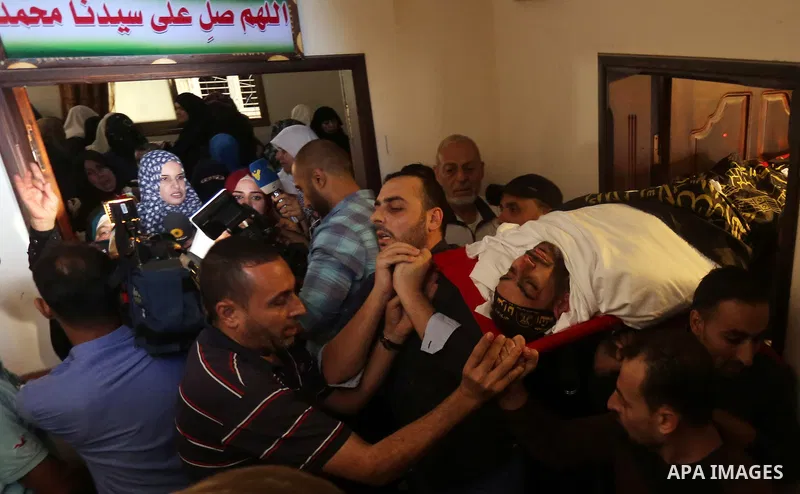 Palestinian mourners carry the body of Hassan Abu Hassanin in Bureij refugee camp in central Gaza Strip on October 31, 2017, during the funeral of Palestinians who were killed the previous day in an Israeli operation to...